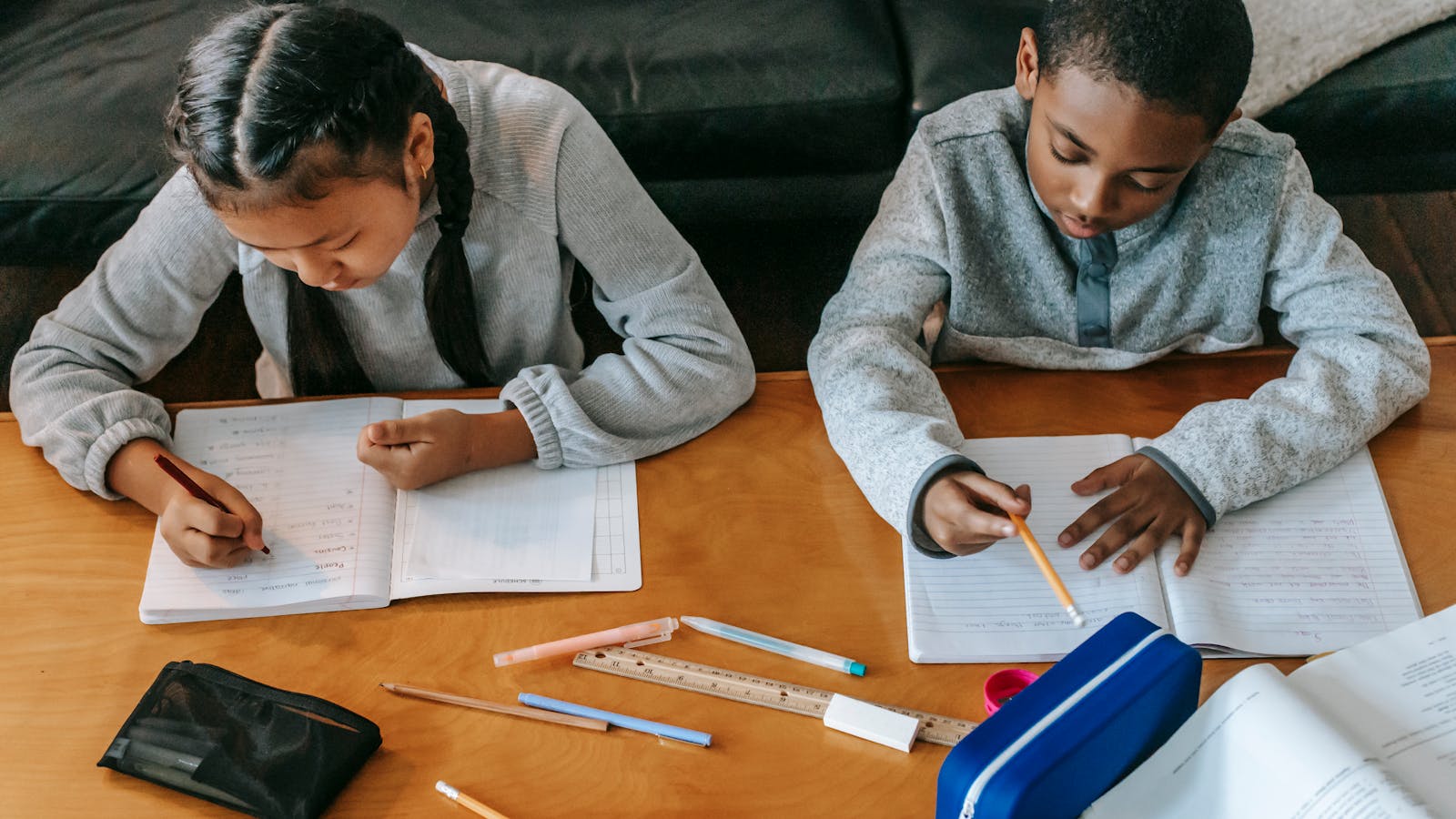 Children sitting at a table and working on homework together