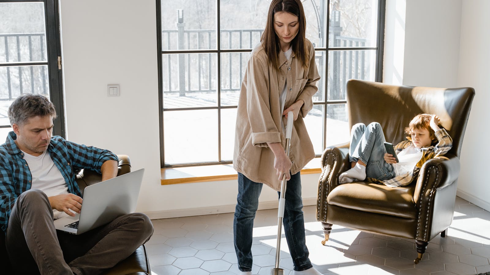 A parent wiping the floor in a bright living room