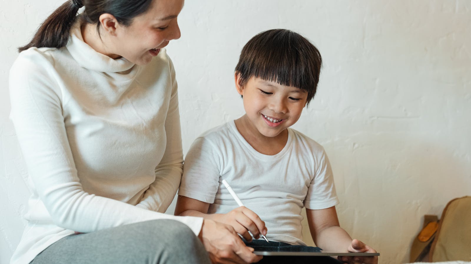 A parent and child looking at a tablet together at home