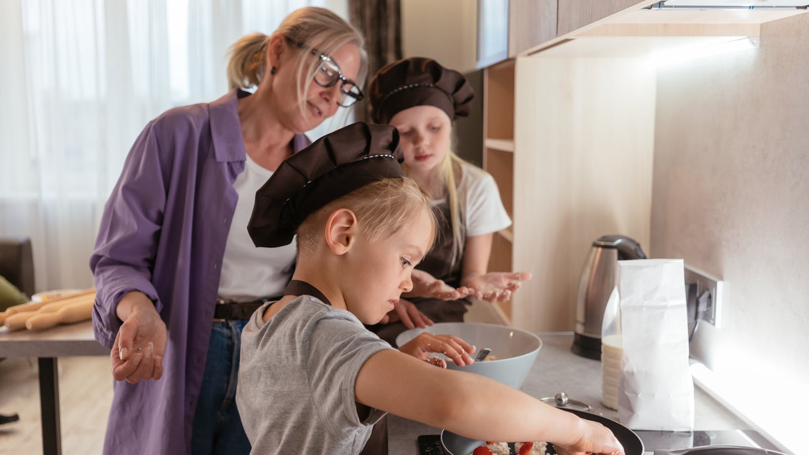 A child cooking in a kitchen and learning responsibility through a household task